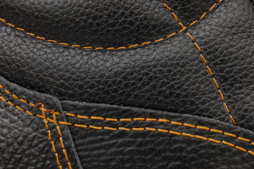 Orange stitching on black leather. Leather texture. Black leather close-up.