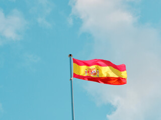 Spanish flag on the flag pole waving on the wind in Madrid, Spain. Concepts of patriotism and freedom