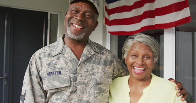 Video of happy african american senior soldier embracing wife and looking at camera
