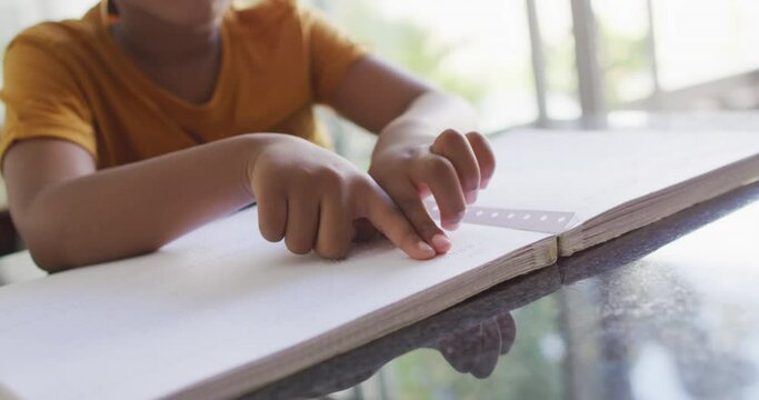 Video of midsection of african american blind boy reading in braille