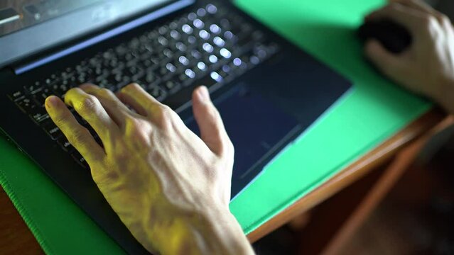 Playing computer game on laptop with colorful decoration lights