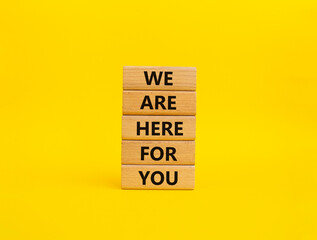 Help symbol. Wooden blocks with words 'We are here for you'. Beautiful yellow background. Business and 'We are here for you' concept. Copy space.