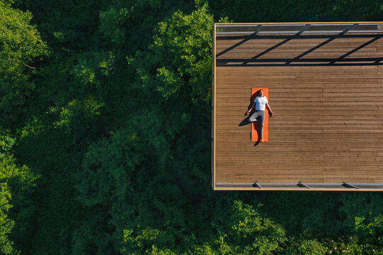 Young woman doing yoga on the balcony