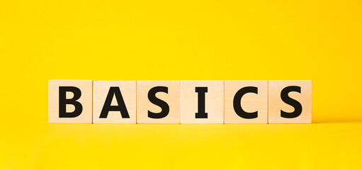 Basics symbol. Concept word Basics on wooden cubes. Beautiful yellow background. Business and Basics concept. Copy space.