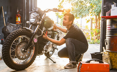 mechanic working on motorcycle at custom bike shop in Bangkok