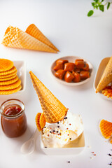 Fresh sweet ice cream with caramel sauce, waffles, cones. Summer food concept.