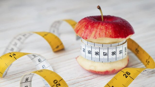 Diet and weight loss concept. A tape measure twisted around a bitten red apple as a diet concept. healthy lifestyle. healthy food. healthy eating.nutritionist