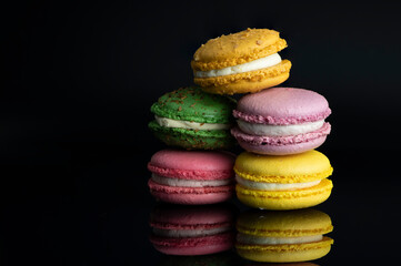 Colorful french macarons on black background