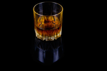 Glass of whiskey on a black background