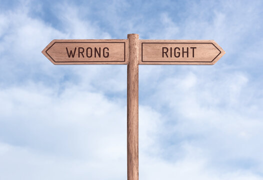 Wrong or Right concept. Words in opposite directions on signpost with sky background