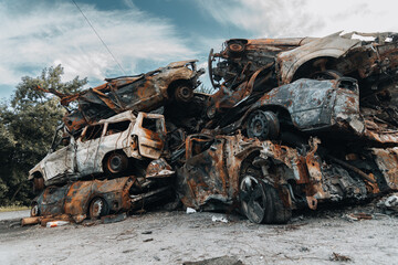 Fototapeta na wymiar BUCHA, UKRAINE 22.06.2022 Irpin, Bucha. Car cemetery. Cars destroyed as a result of the war. A mountain of cars burned.