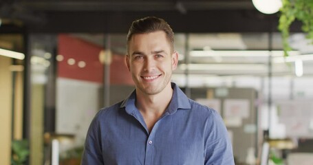 Portrait of happy caucasian businessman looking at camera at office