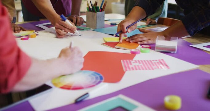 Diverse business people discussing work with schema during meeting at office