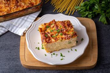 Pasta casserole bechamel sauce topped with melted mozzarella cheese and served in a white baking dish on a table (Turkish name; firinda makarna or firin makarna)
