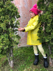a little child with face painting held out his palms to a christmas tree and waiting . background  a worn brown wall