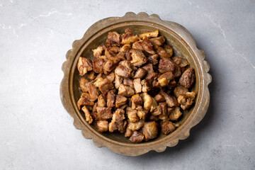 Muslims Traditional Sacrifice holiday food lamb, Turkish roasted meat in copper pot on table top. Turkish Kavurma. (Turkish name; Kurban kavurma)