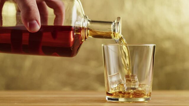 Brandy or whiskey close-up. Luxury cognac. Alcohol amber drink with ice, drinking rum, liqour beverage in glass.