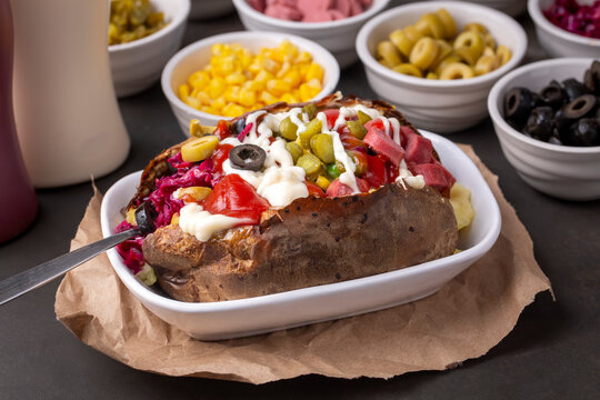 Kumpir, Turkish baked potato with cheese, corn, sausage, ketchup, mayonnaise and olives. This kumpir is traditional turkish food