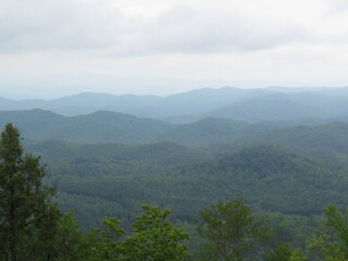 Fototapeta premium foggy forested mountains under cloudy sky