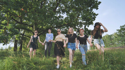 Cheerful girls run out of town on a summer day.