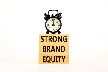 Strong brand equity symbol. Concept words Strong brand equity on wooden blocks on a beautiful white table white background. Black alarm clock. Business, finacial and strong brand equity concept.