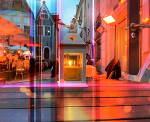 night city street cafe lantern with candle on wooden table people relax view from window glass vitrunes reflection Tallinn old town urban lifestyle