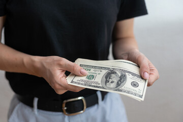 Young woman with money on grey background