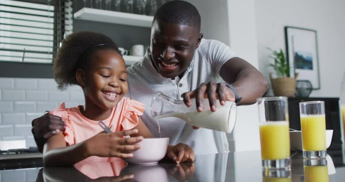 Vertical video of african american father and daughter eating breakfast