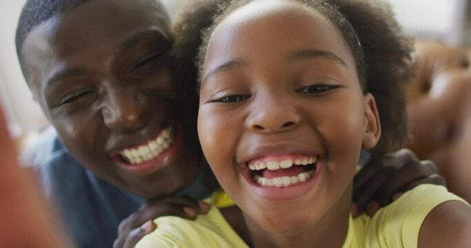 Vertical video of african american father and daughter talking and playing