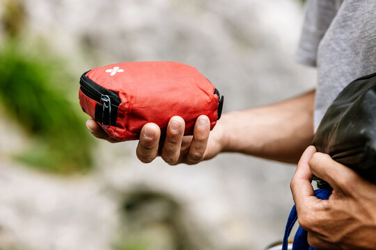Male Hiker Holding Red Pouch