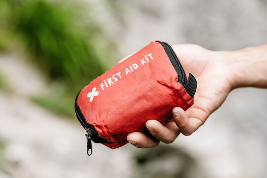 Male Hiker Holding Red Pouch