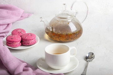 breakfast of herbal tea with lavender and sweet colorful dessert macarons on white background