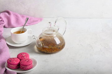 breakfast of herbal tea with lavender and sweet colorful dessert macarons on white background, copy space