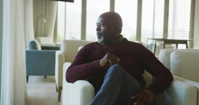 Video of thoughtful senior african american men sitting in living room alone