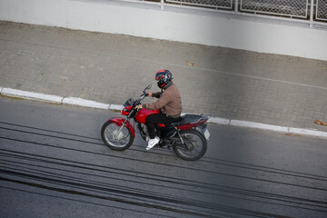 Fototapeta na wymiar Motoqueiro na estrada em movimento com moto vermelha.