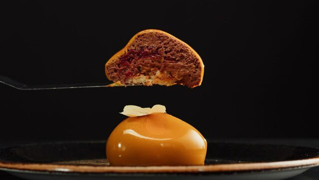 Mousse orange cake, creamy dessert close-up. Almond dacquoise, raspberry confit, crispy layer with caramelized hazelnuts and raspberry powder, mousse based on bitter chocolate.