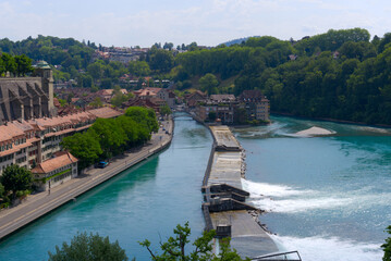 Fototapeta na wymiar Aerial view of Aare River with watergate at City of Bern on a sunny summer day. Photo taken June 16th, 2022, Bern, Switzerland.