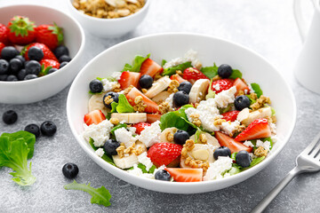 Fruit and berry salad with fresh strawberry, blueberry, banana, cottage cheese and granola with almond. Healthy food, diet breakfast