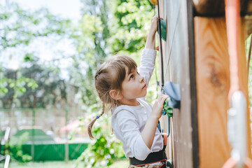 Little girl preschooler climbing on the stand