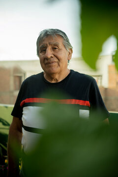 Retrato de se&ntilde;or adulto maduro serio mirando a camara entre  plantas 