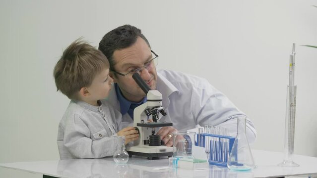 Father and son using a microscope in the laboratory