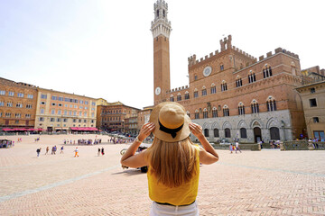 Fototapeta premium Holidays in Tuscany. Back view of beautiful woman visiting main square in Siena city, Tuscany, Italy.