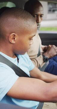 Vertical video of african american father and son during driving lesson