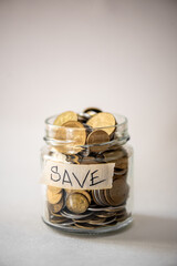 Clear glass jar for tips with coins money isolated on white. Finance concept