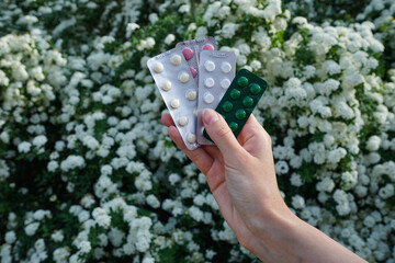 Female hand hold pills from outdoors. Health and medical concept.