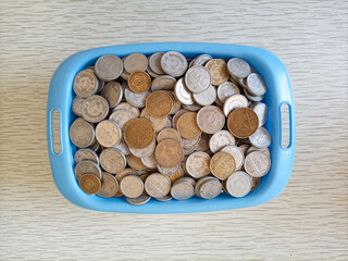 Pakistani currency coins in a plastic basket