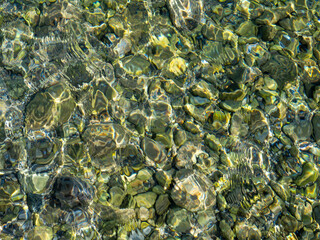 Fototapeta na wymiar waves on the water surface and stones in the water