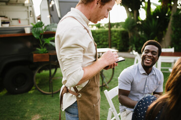 Waiter checking order of clients