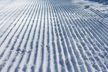 Snow stripes. Snow groomer print, close-up.