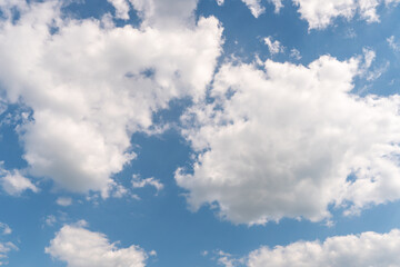 Obraz na płótnie Canvas Beautiful white fluffy clouds on a blue sky background on a sunny day.